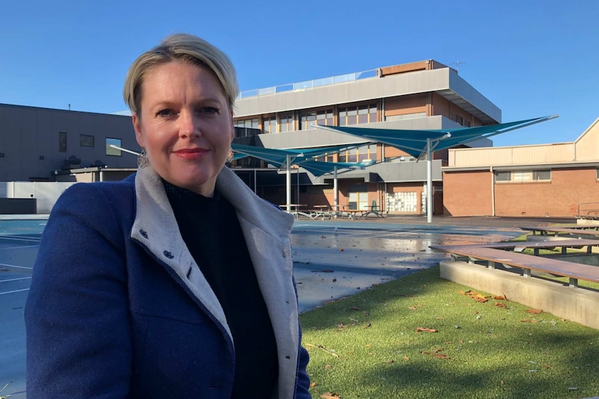 Sex educator Lael Stone stands in front of a school quadrangle.