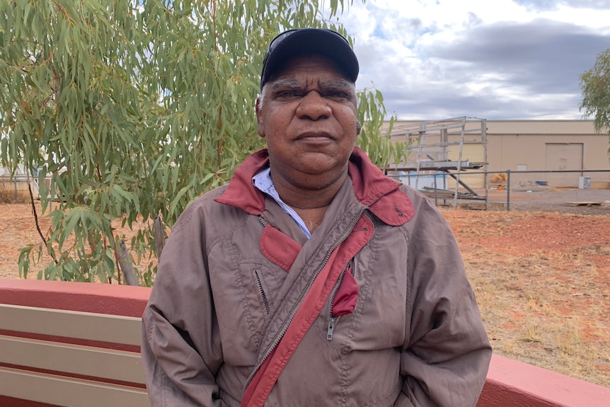 Norman Frank in a coat standing in front of a gum tree.