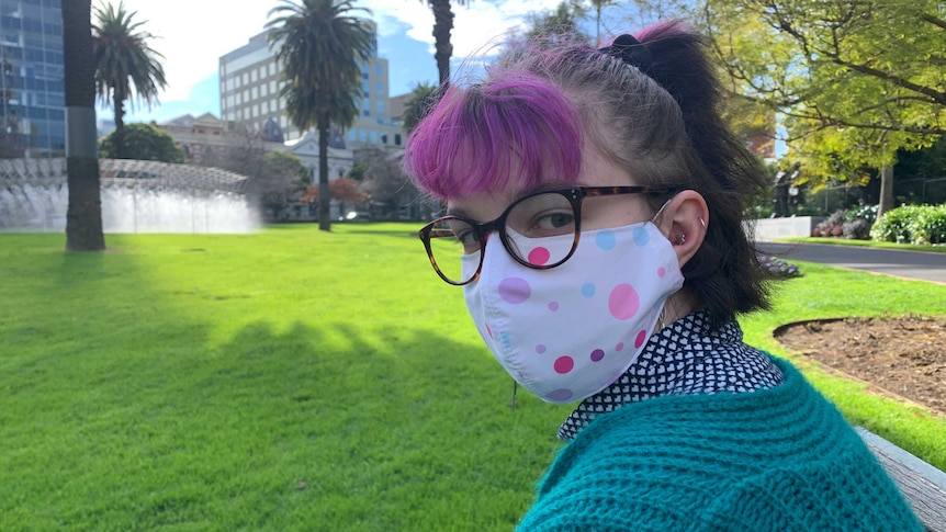 A young woman with a face mask in a park