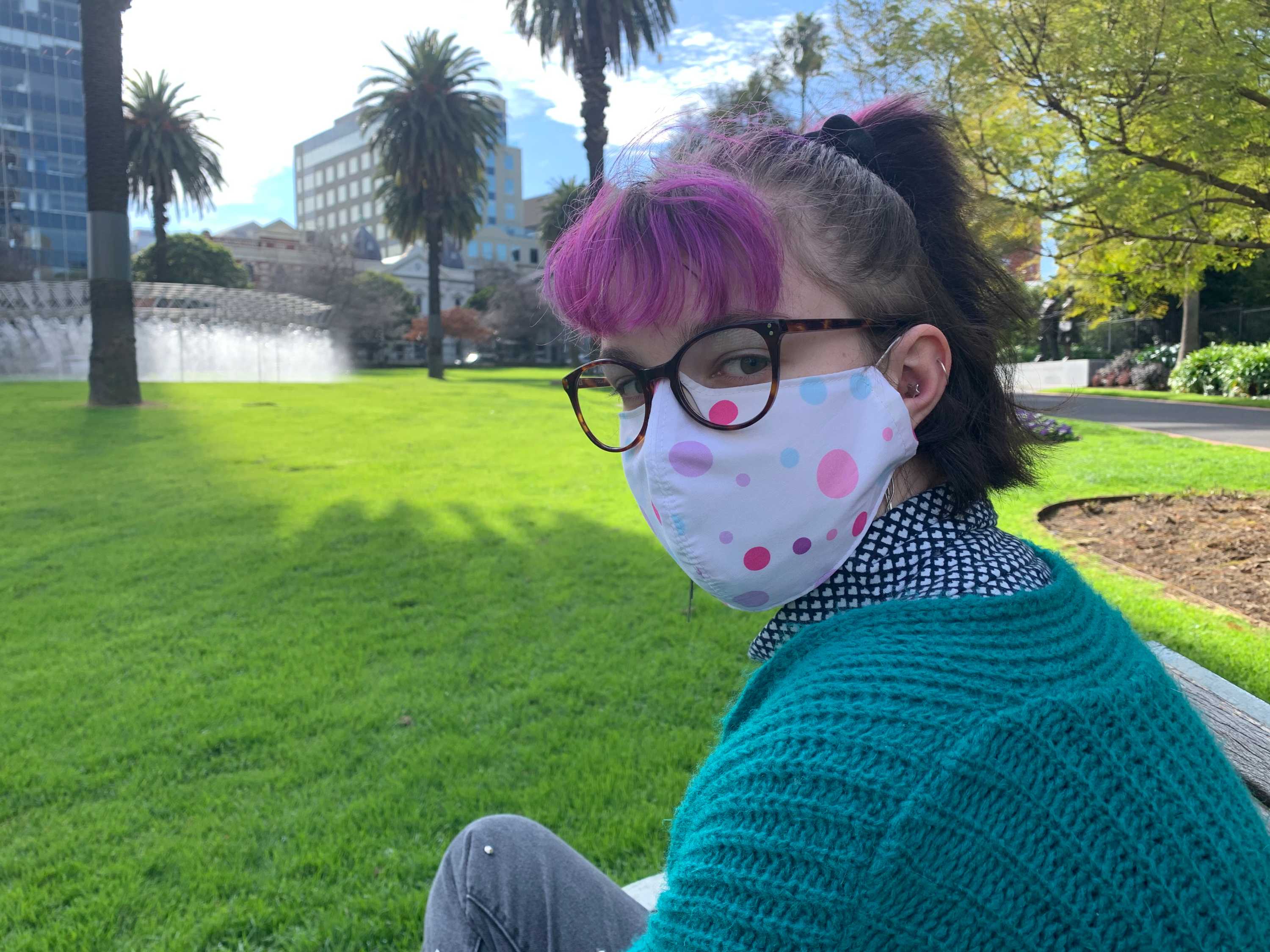 A young woman with a face mask in a park