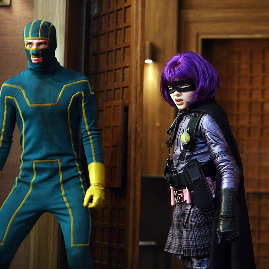 Aaron Taylor-Johnson and Chloë Grace Moretz in the movie Kick-Ass. They are wearing shabby superhero outfits.