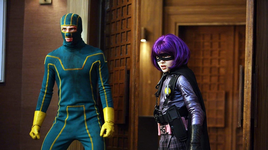 Aaron Taylor-Johnson and Chloë Grace Moretz in the movie Kick-Ass. They are wearing shabby superhero outfits.