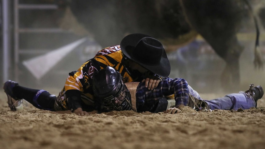 A protection athlete crouches over Jay Borghero