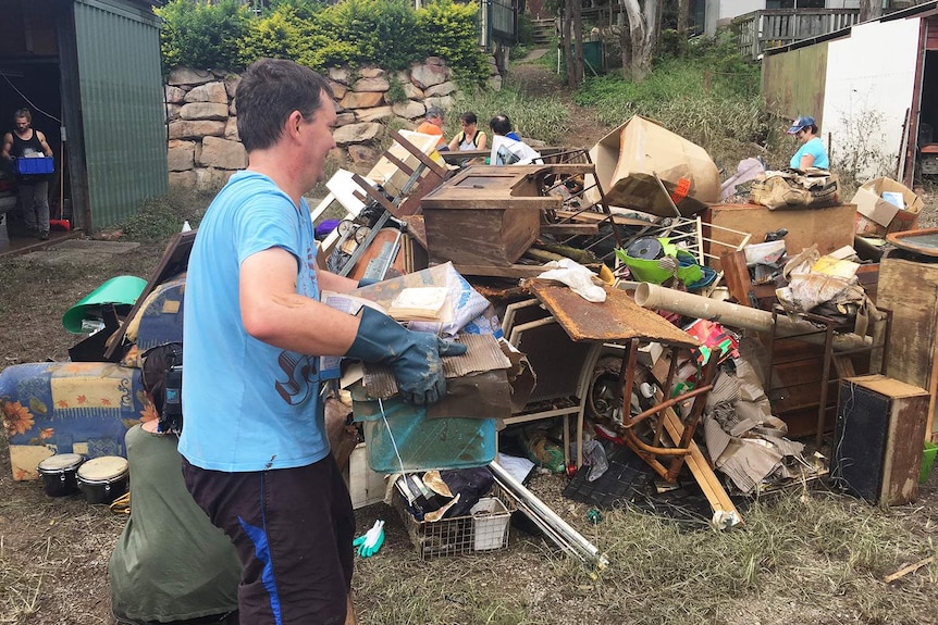 Residents dump possessions in a pile that were destroyed in floodwaters at Logan