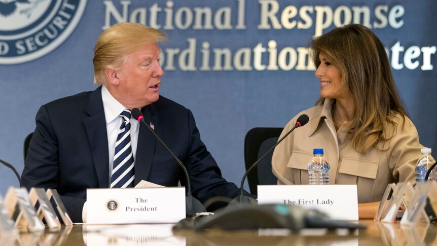 President Donald Trump sits next to Melania Trump with the sign "National Response Coordination Centre" behind them.