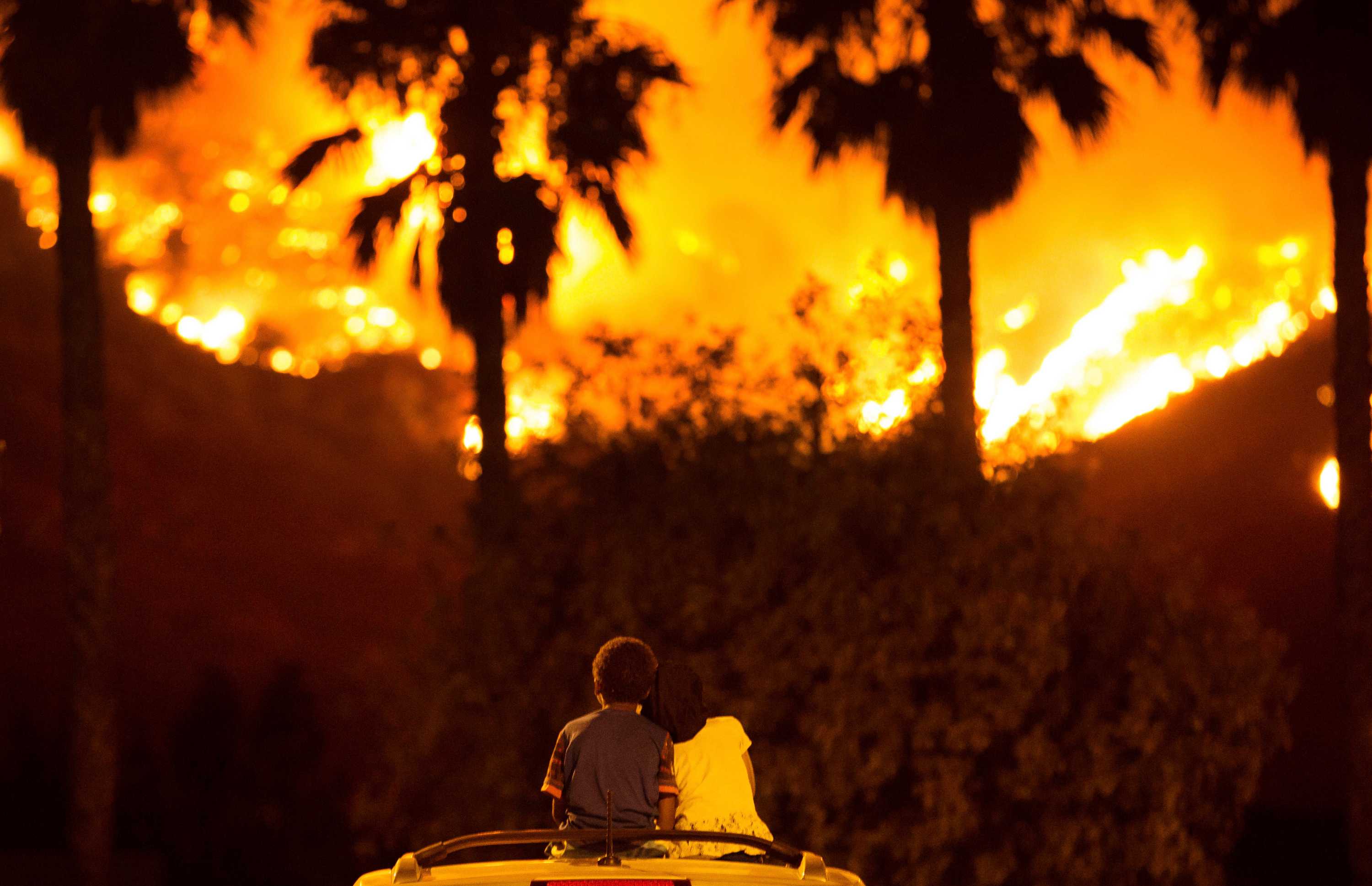 King and Princess Bass sit and watch the Holy Fire burn from on top of his parents' car in California.
