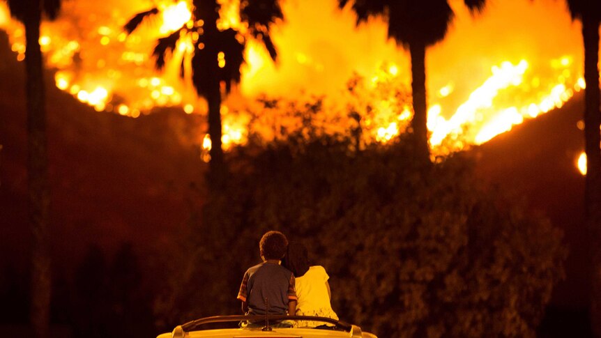 King and Princess Bass sit and watch the Holy Fire burn from on top of his parents' car in California.