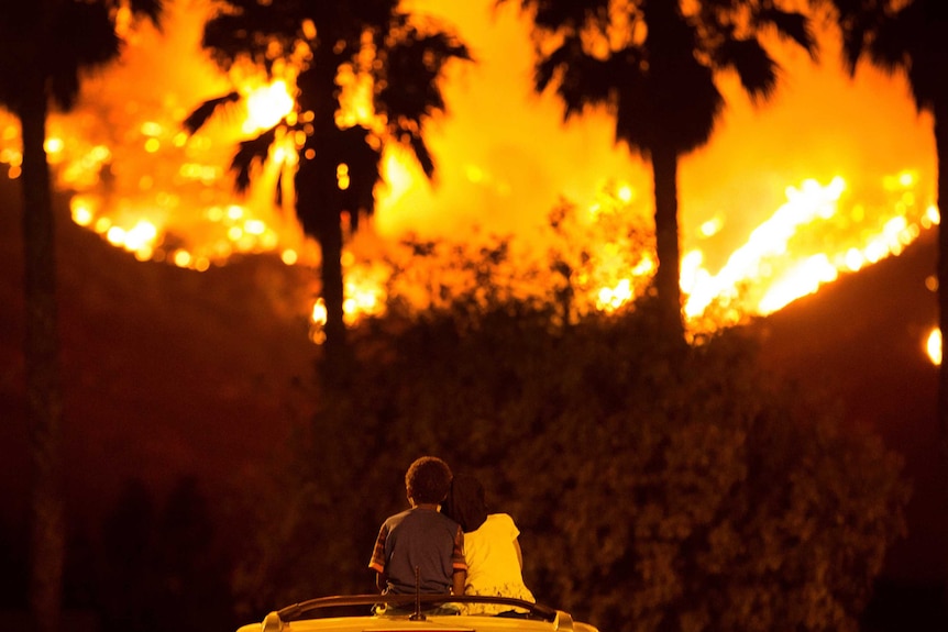 King and Princess Bass sit and watch the Holy Fire burn from on top of his parents' car in California.