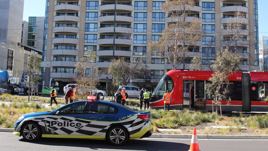 Emergency services and Capital Metro workers on Northbourne Avenue with a stopped tram.