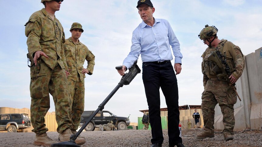 Opposition Leader Tony Abbott uses a mine detector during a visit to Afghanistan.