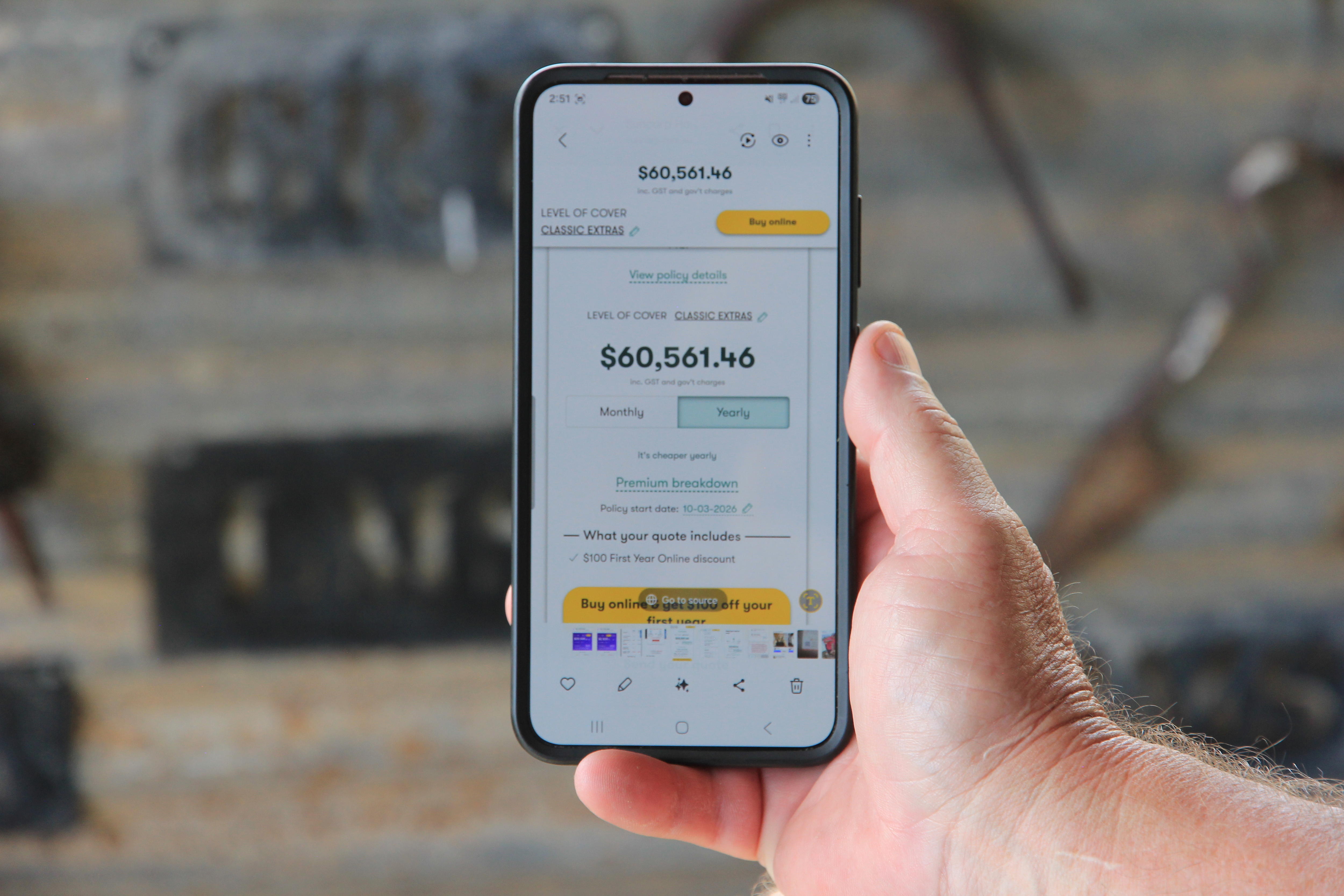 Una mano sostiene un teléfono con una oferta de 60.561 dólares en la pantalla