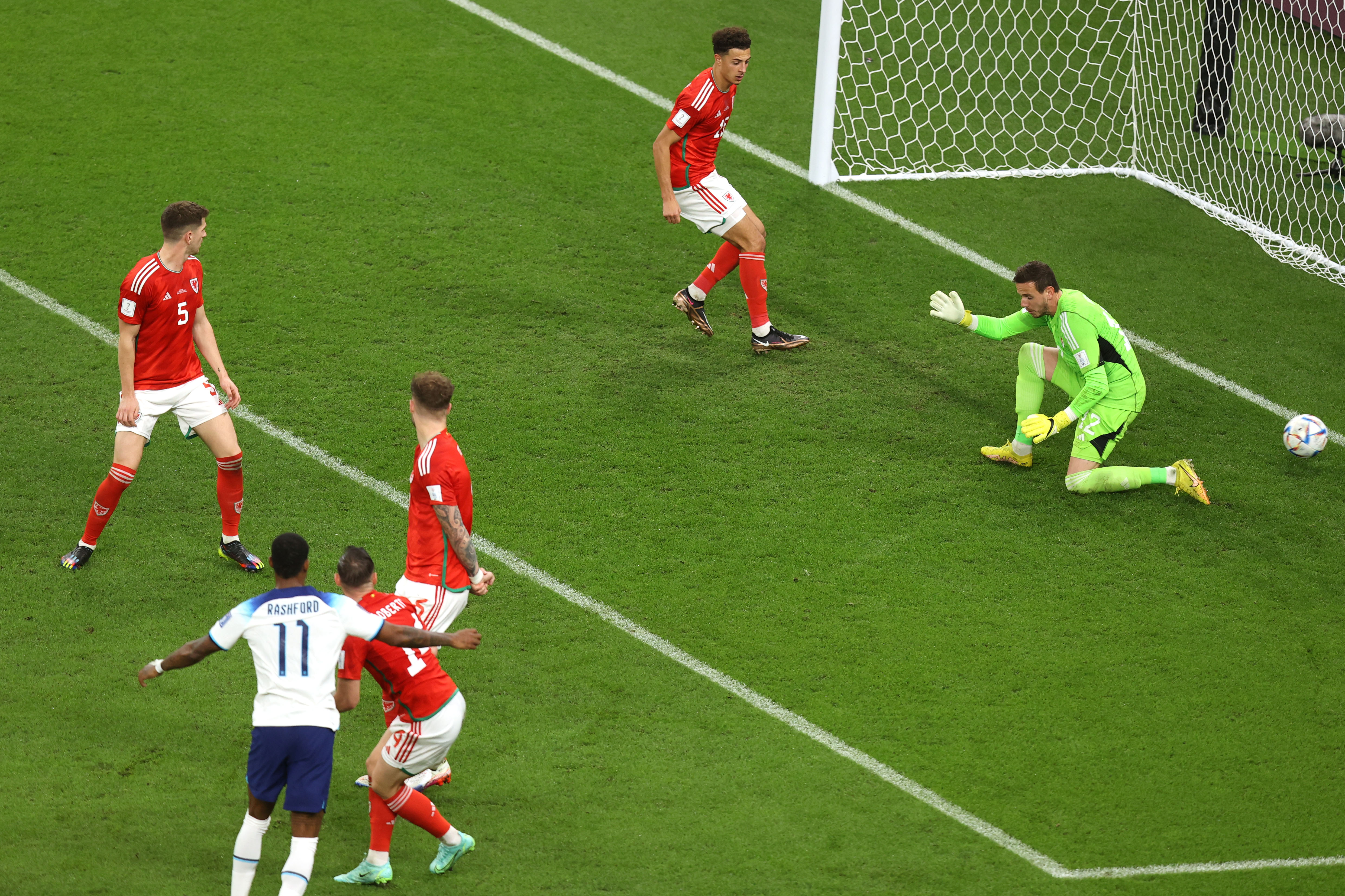 Players watch on as goalkeeper Danny Ward lets a ball go between his legs and into the goal