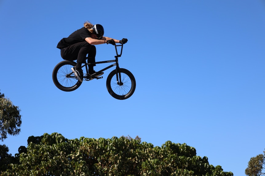 A BMX rider doing a jump from a ramp.