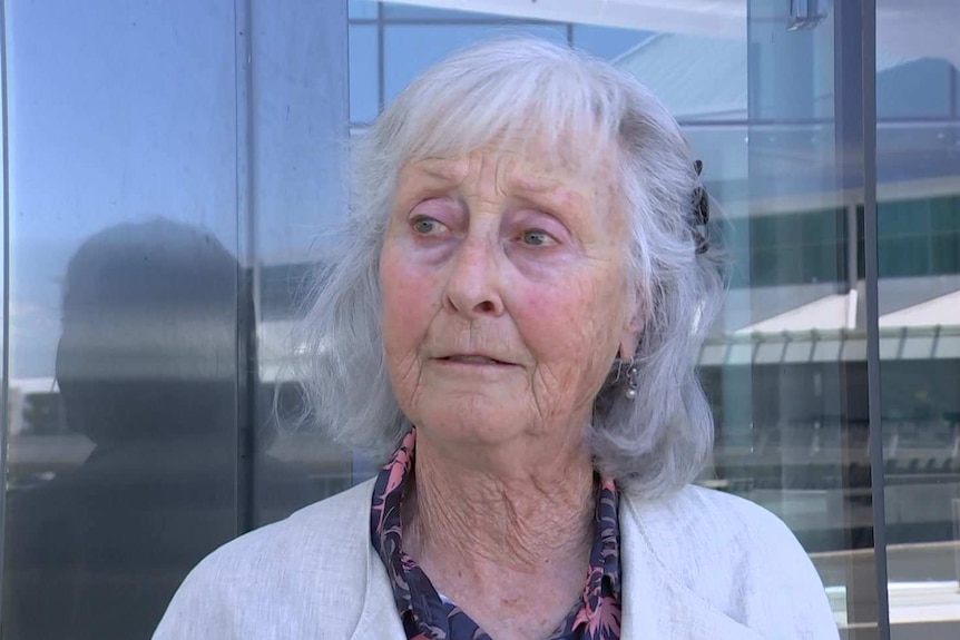 A woman speaks outside an airport.