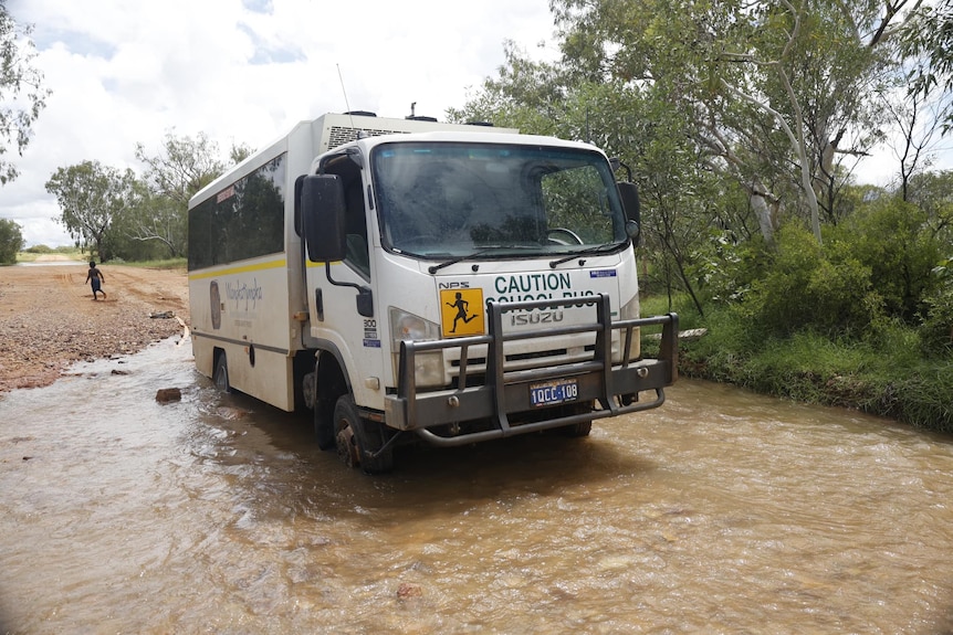 A school bus crosses a creek