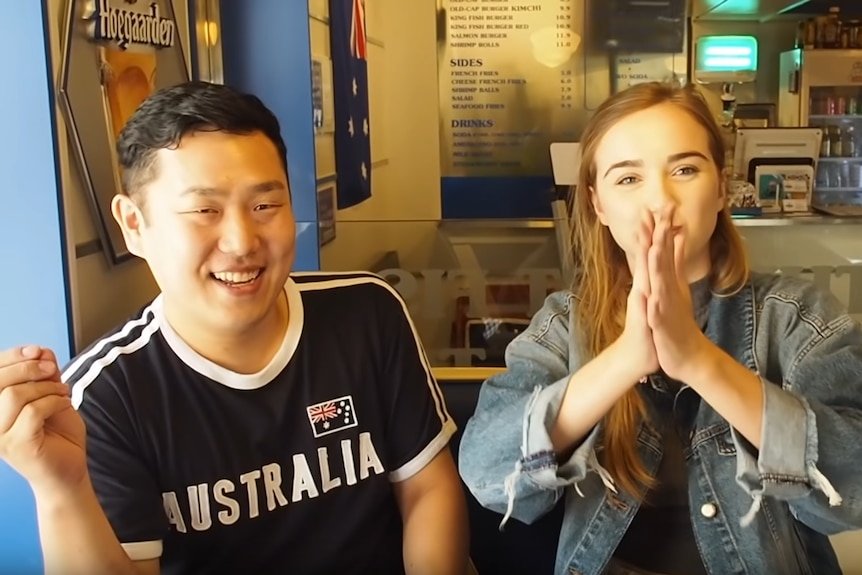 A Korean man wearing an Australia shirt with a blonde teenager HojuSara clasping her hands to her face.