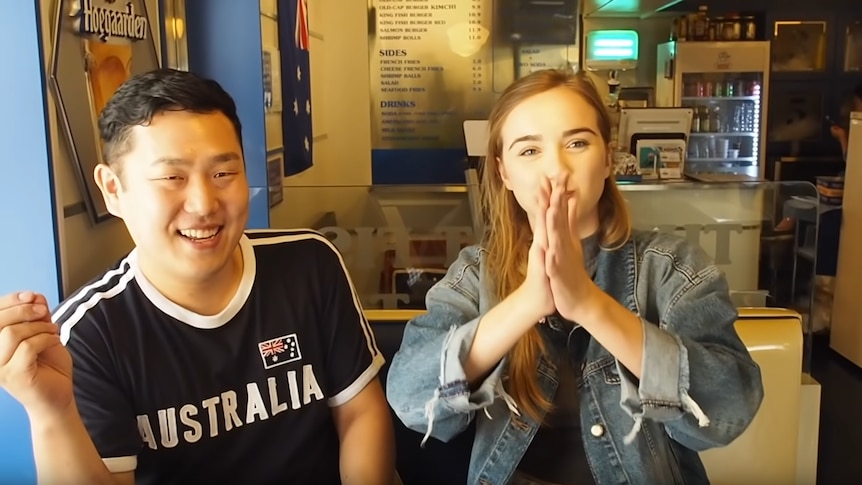 A Korean man wearing an Australia shirt with a blonde teenager HojuSara clasping her hands to her face.