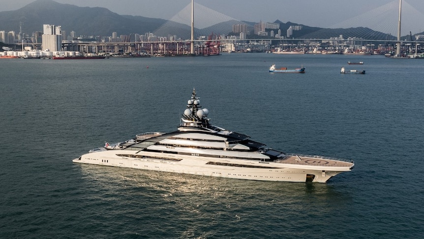 Superyacht anchored with Hong Kong in the background. 