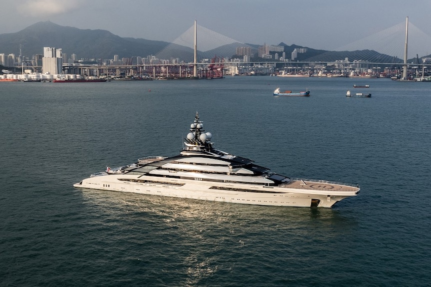 Superyacht anchored with Hong Kong in the background. 