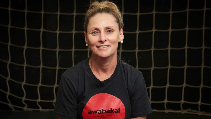 Image of a woman in a black T-shirt that says Awabakal Our People