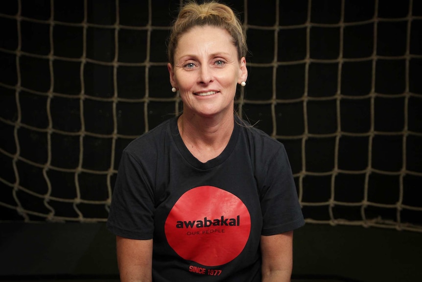 Image of a woman in a black T-shirt that says Awabakal Our People