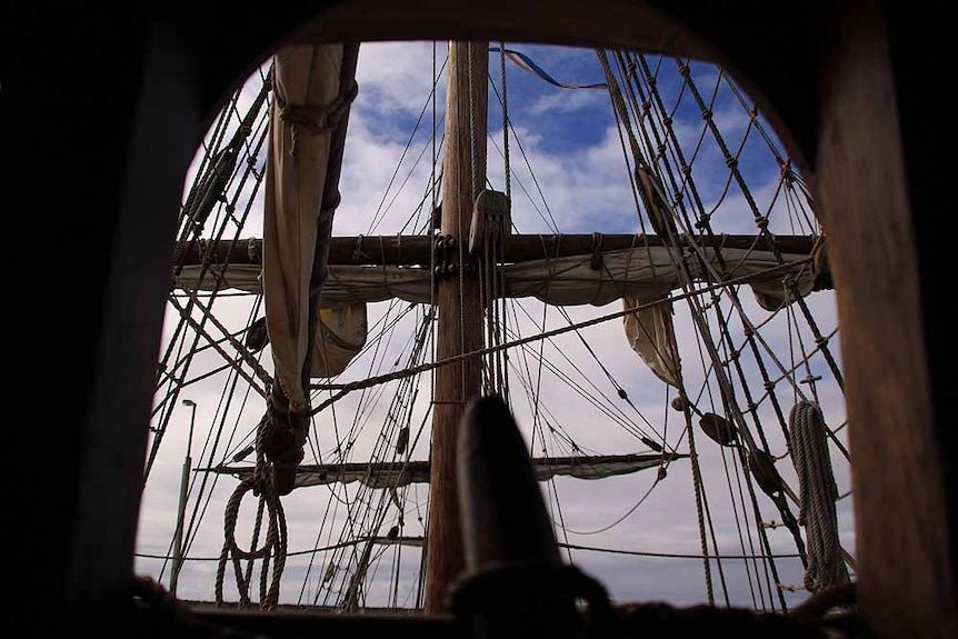 Mast and rigging seen through a wooden window frame