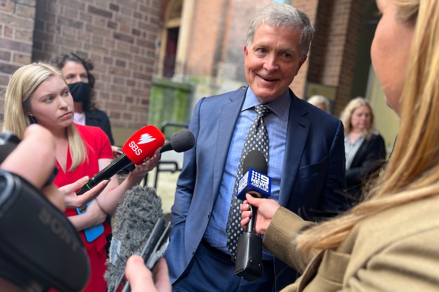 a man outside a court speaking to the media