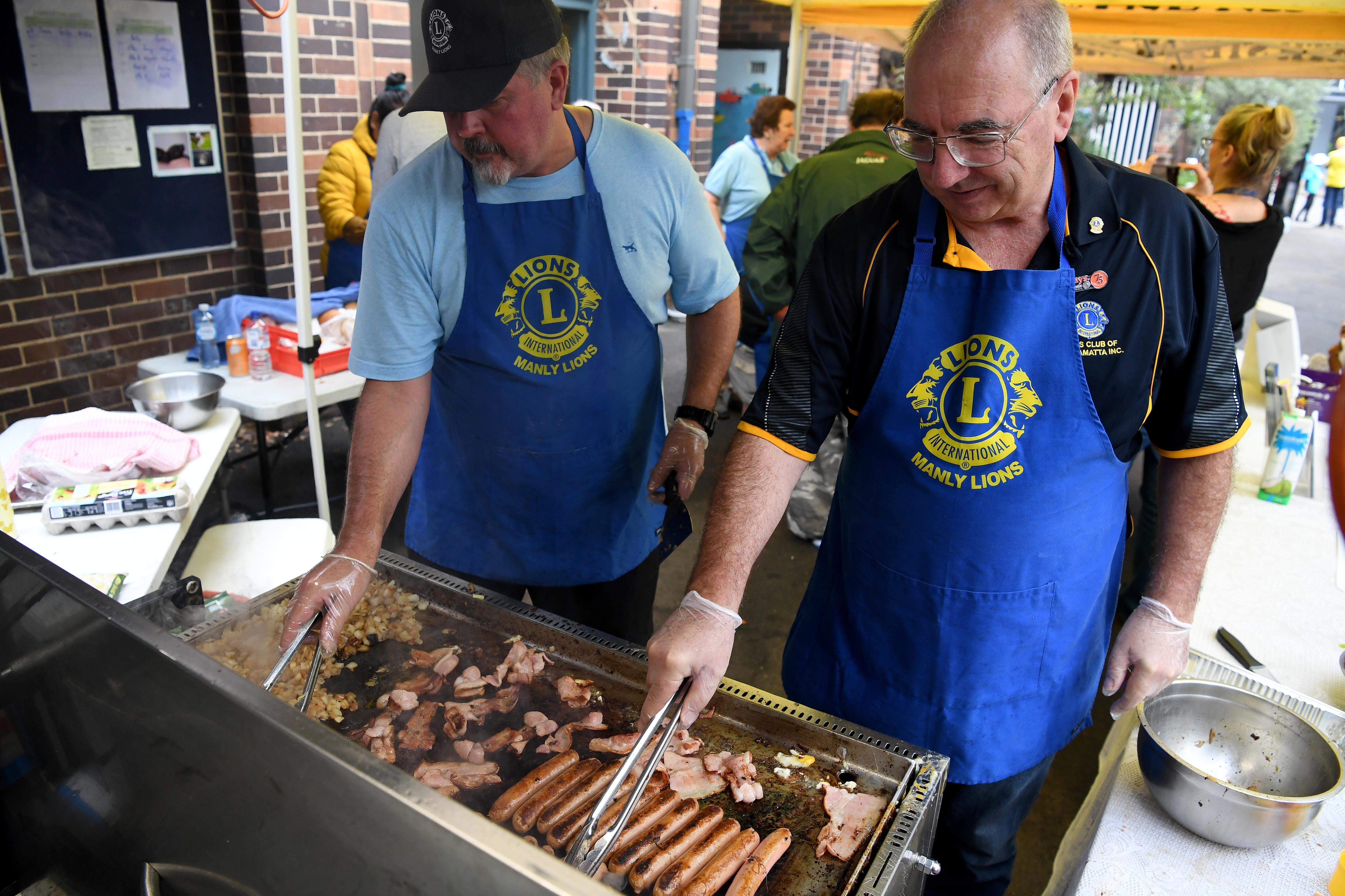 two men cooking sausages