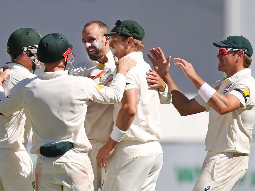 Nathan Lyon (C) of Australia celebrates the wicket of Ajinkya Rahane of India during day three of the First Test match between Australia and India at Adelaide Oval