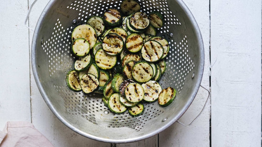 Sliced, chargrilled zucchini in a colander