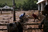 Men take out a bag from a house flooded with mud after a dam owned by Vale SA and BHP Billiton burst in Brazil.