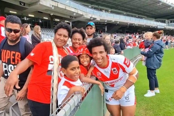 Woman surrounded by fans at NRLW game
