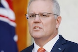 Morrison looks up in concentration as he's speaking at a press conference