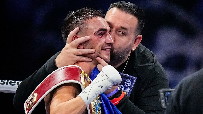 Jason Moloney is kissed on the head by his trainer after winning a fight
