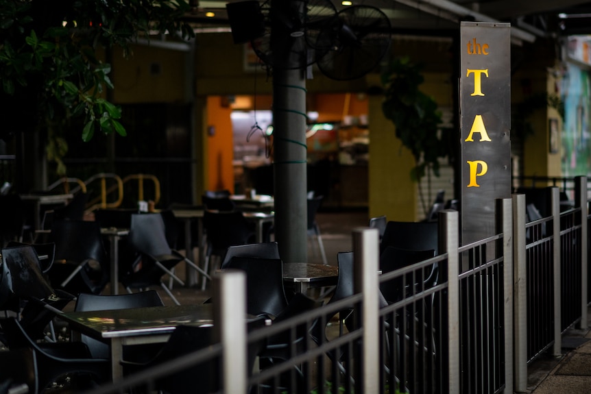 Empty tables and chairs outside Darwin bar The Tap.