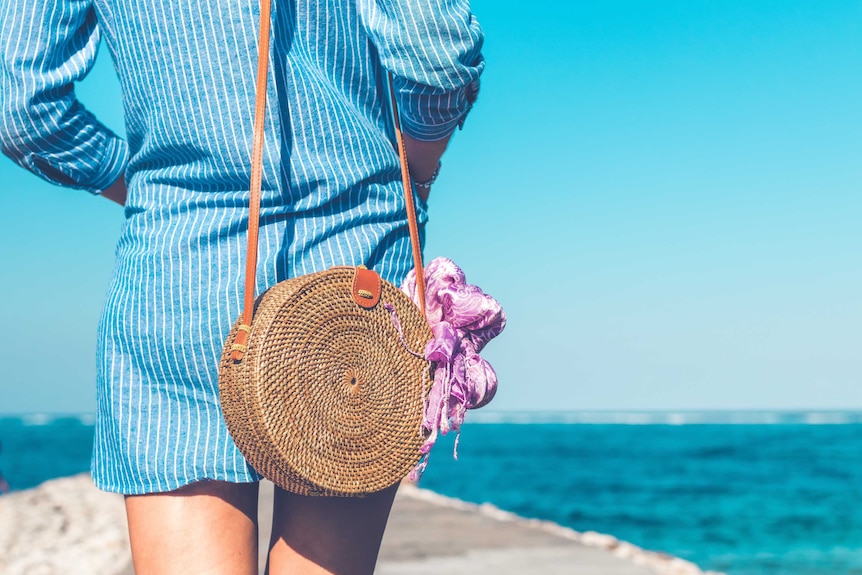 Woman carries bag with scarf tied to it