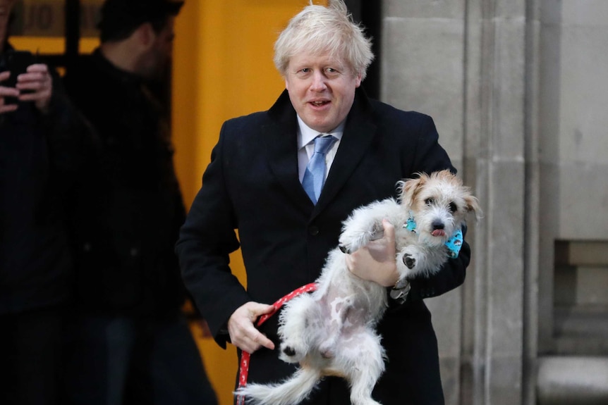 Boris Johnson holding a dog outside a polling station