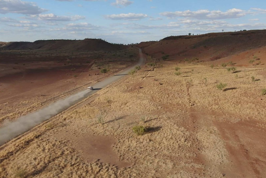 Police patrol a remote road with sandy desert landscape that surrounds them