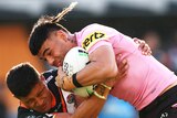 A Penrith Panthers NRL player is tackled by a Wests Tigers opponent.