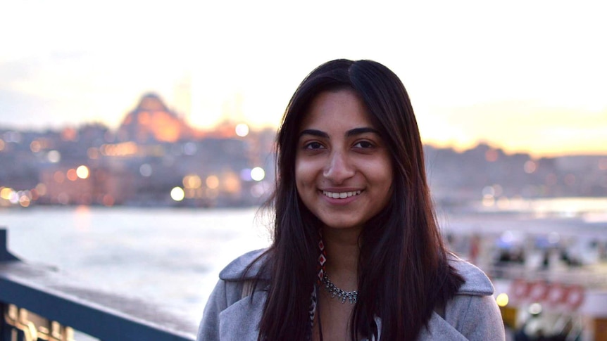 A smiling woman on a bridge