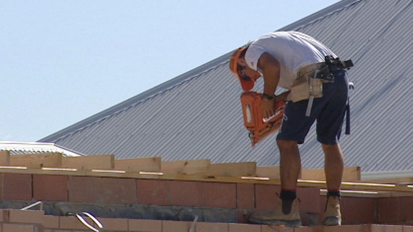 House under construction worker on roof