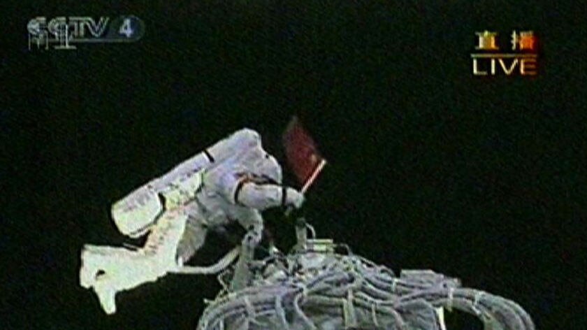 Mr Zhai holds the national flag after exiting the Shenzhou VII.