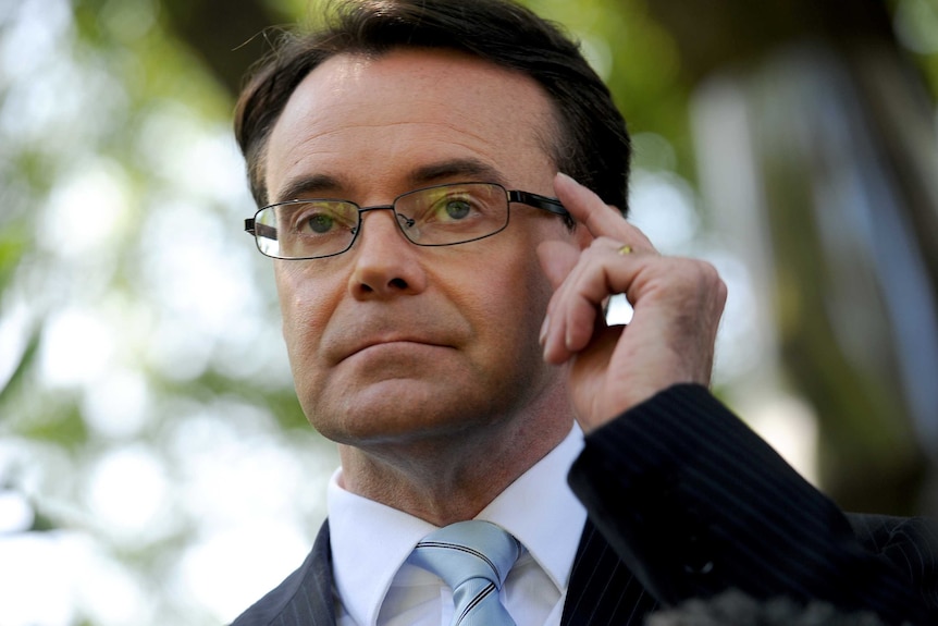 A head shot of Opposition leader Michael O'Brien with his hand on his glasses.