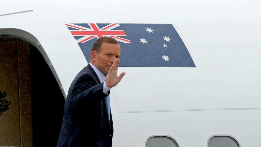 Prime Minister Tony Abbott waves as he leaves Fairbairn RAAF base in Canberra on April 5, 2014.