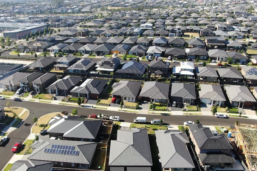 a drone photo taken above streets with dark roofed houses