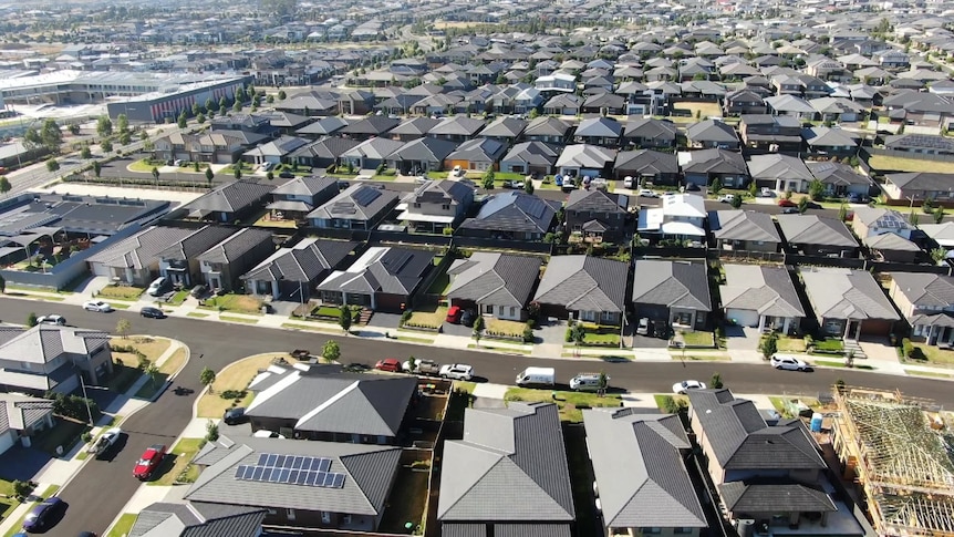 a drone photo taken above streets with dark roofed houses