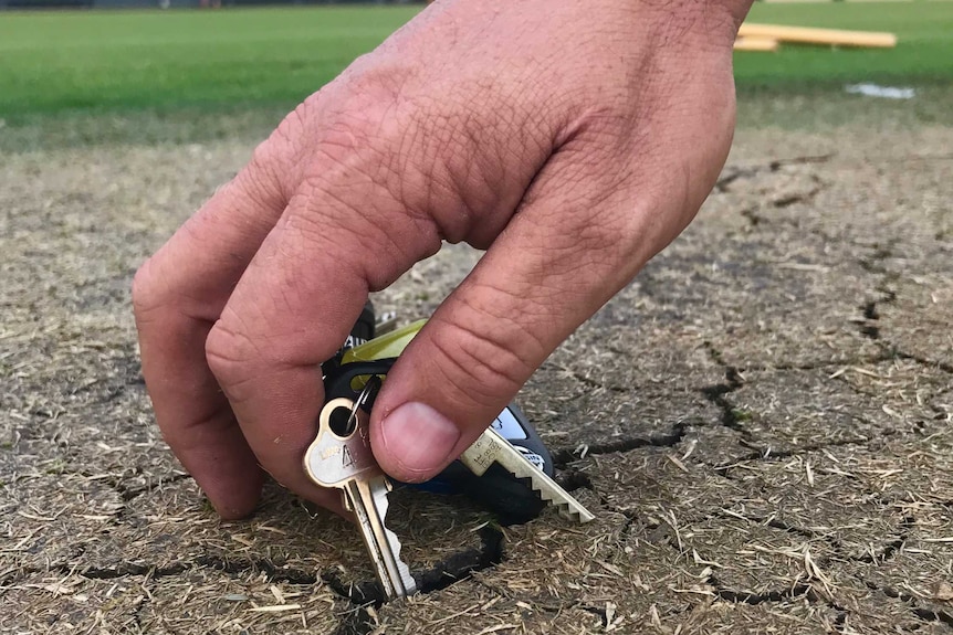 key being stuck into cricket pitch