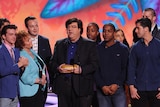 Nickelodeon producer Dan Schneider accepting an award with his co-workers and actors standing around him on stage