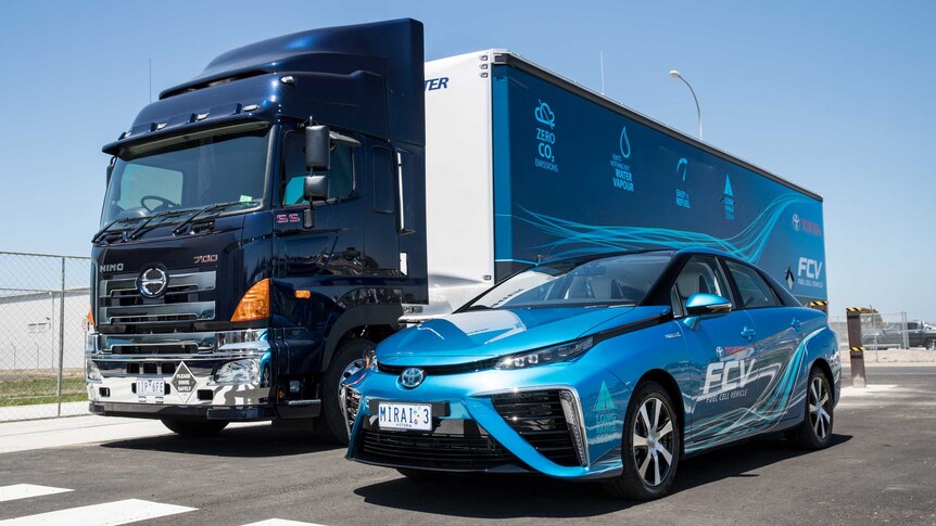 A Toyota Mirai hydrogen car sits alongside a large truck housing a portable refueller.