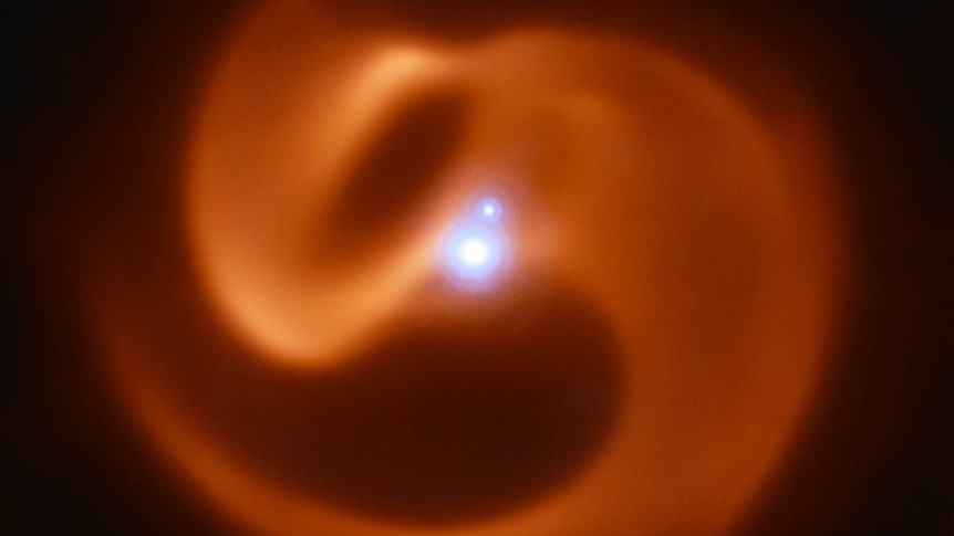 Infrared image of Apep — a swirling orange shape with bright points near its centre